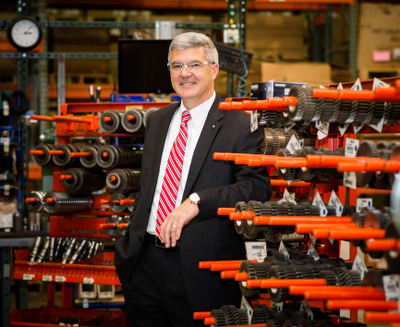 An image of Ray Chambers standing next to racks of gears.